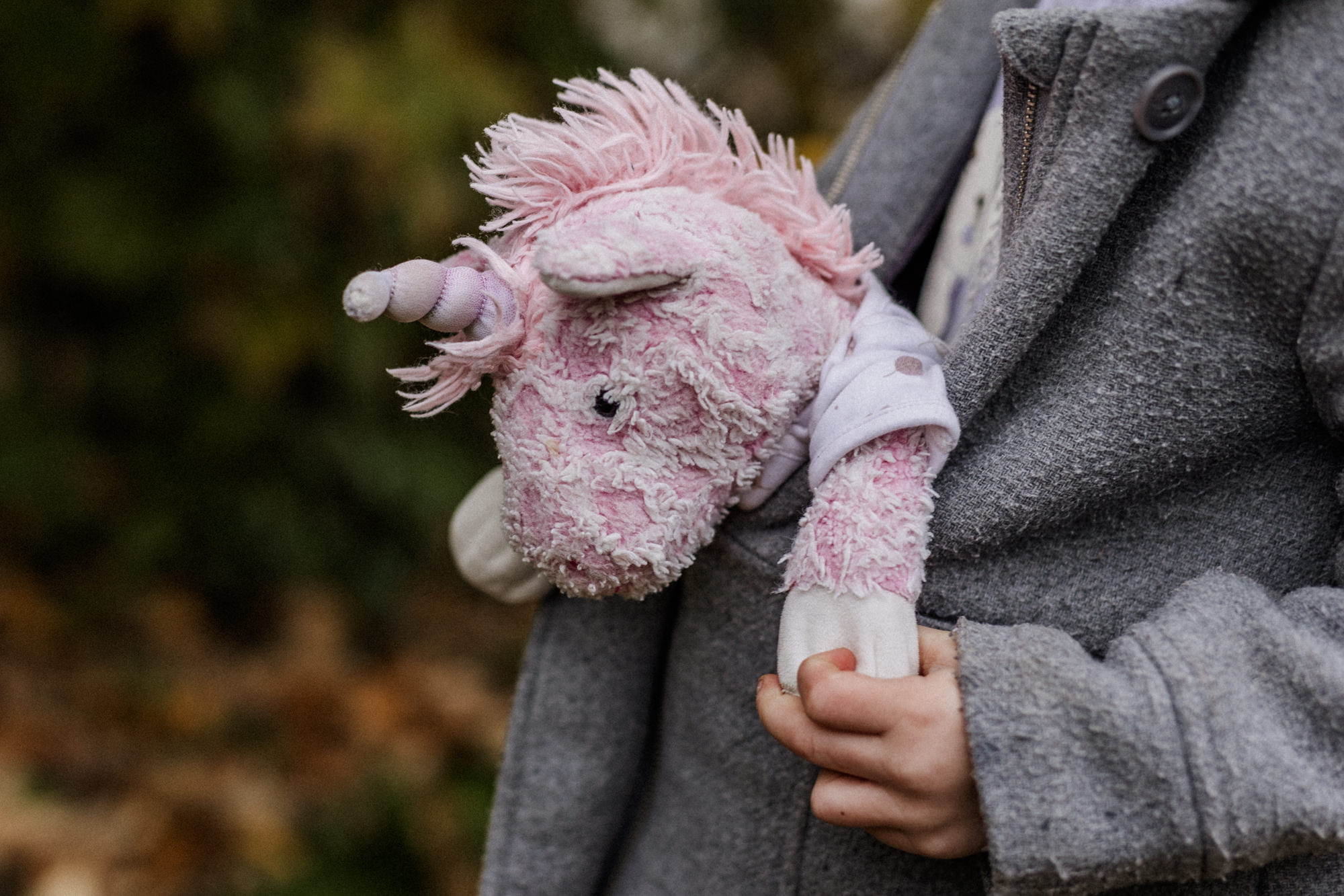 Kind, das sich ein Einhorn vorne in die Jacke gesteckt hat