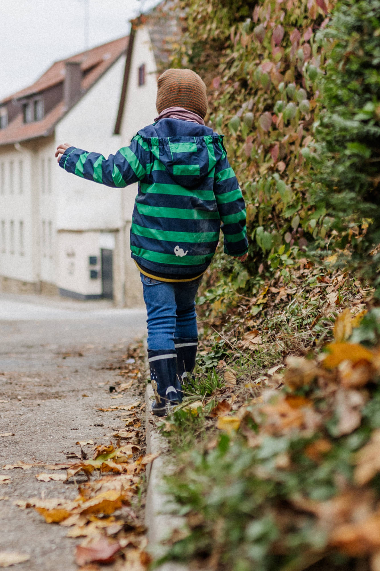 Junge, der auf einem Bordstein balanciert