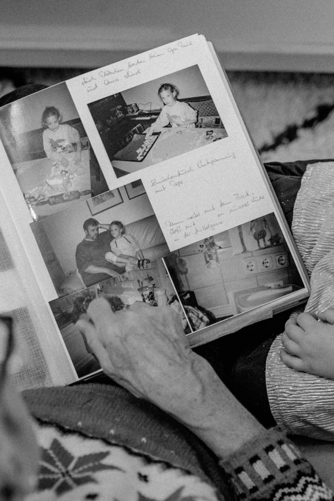 Mutter und Kind der Fotografin blättern in einem alten Familienalbum