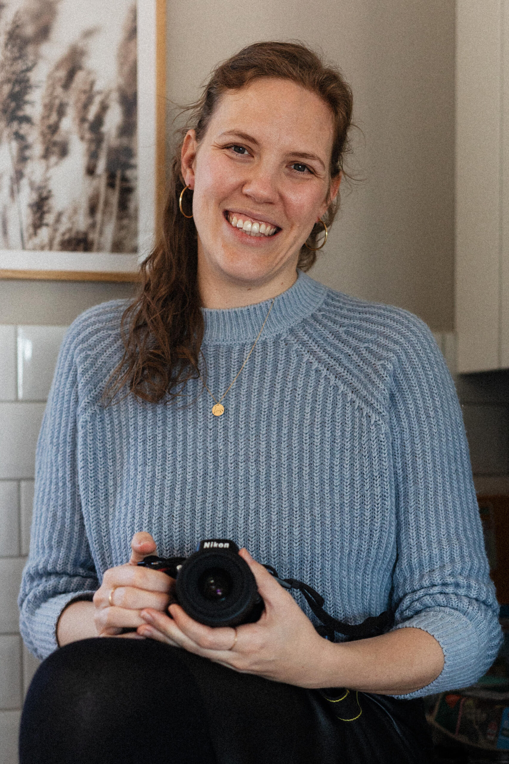 Porträt der lächelnden Fotografin mit Kamera