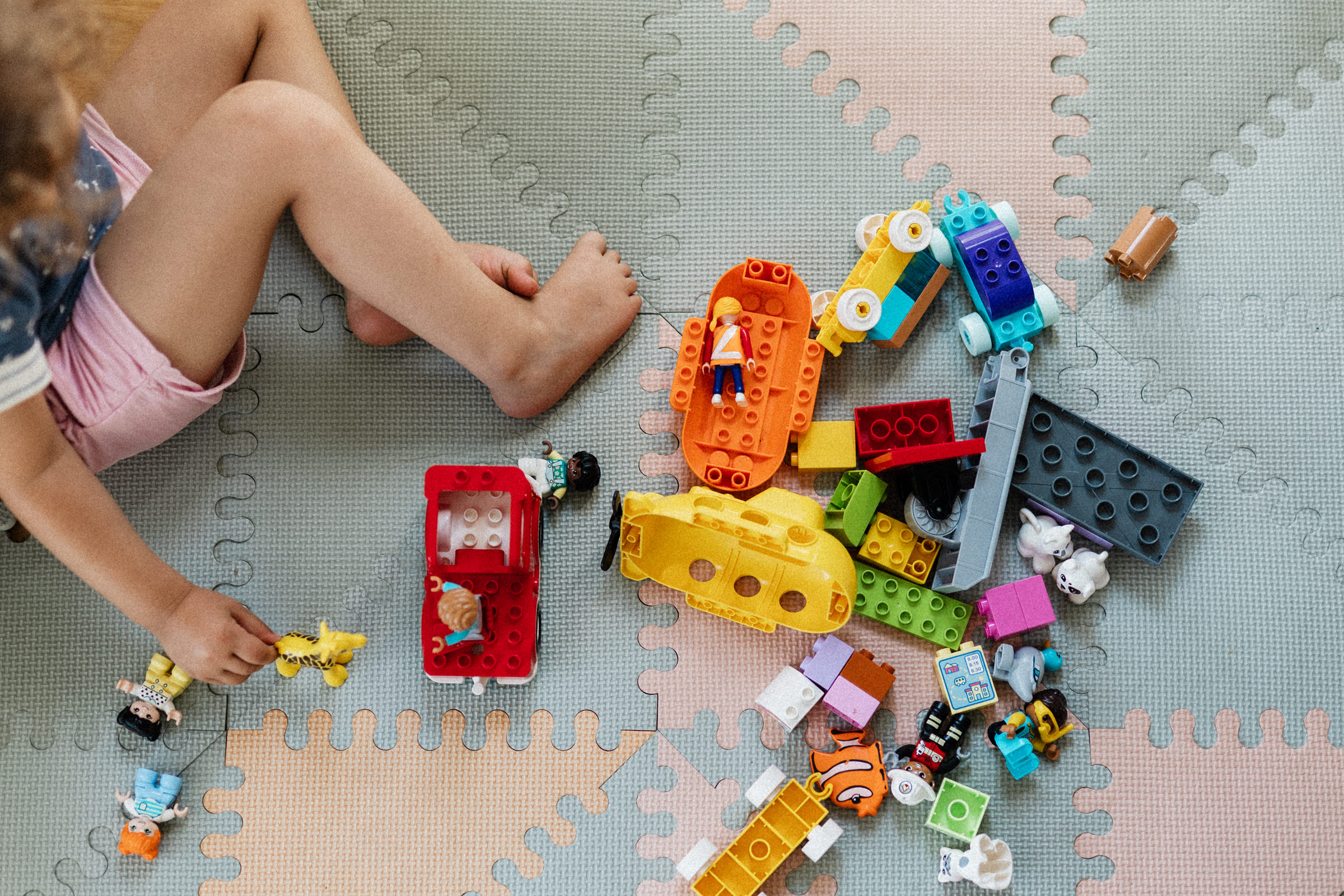 mit bunten Lego-Steinen spielendes Kind