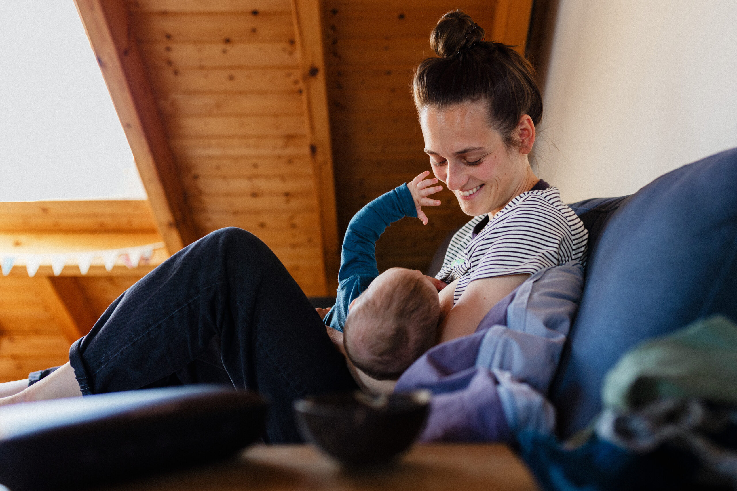stillendes Baby, das beim Stillshooting in Mainz an den Mund seiner Mama greift